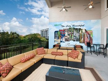 a patio with a couch and chairs and a mural on the wall at The Rialto, Orlando, FL